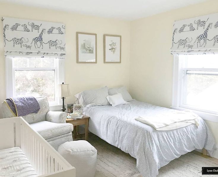 a bedroom with a bed, chair and baby crib