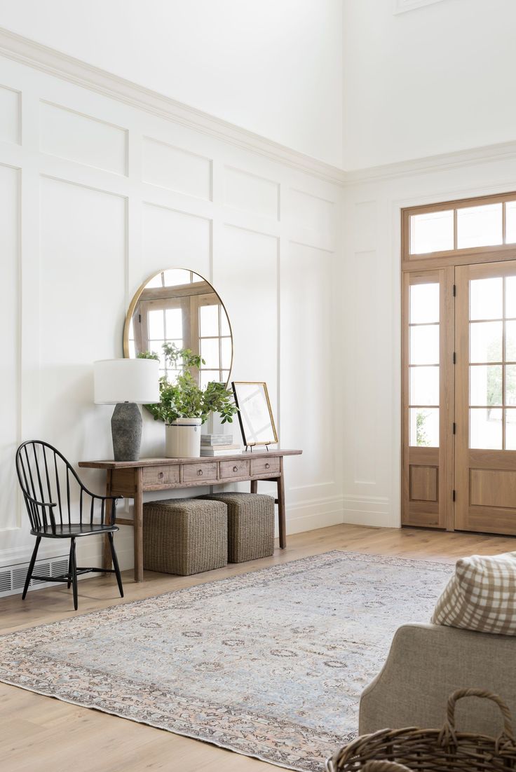 a living room with a rug, chair and mirror on the wall in front of it