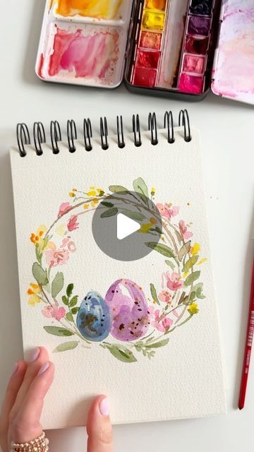 someone is painting an easter card with watercolors