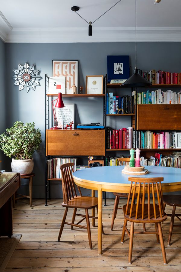 a table and chairs in a room with bookshelves