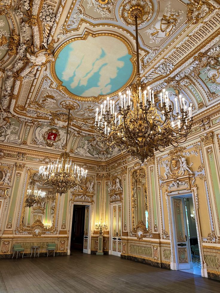 an ornate room with chandeliers and paintings on the walls