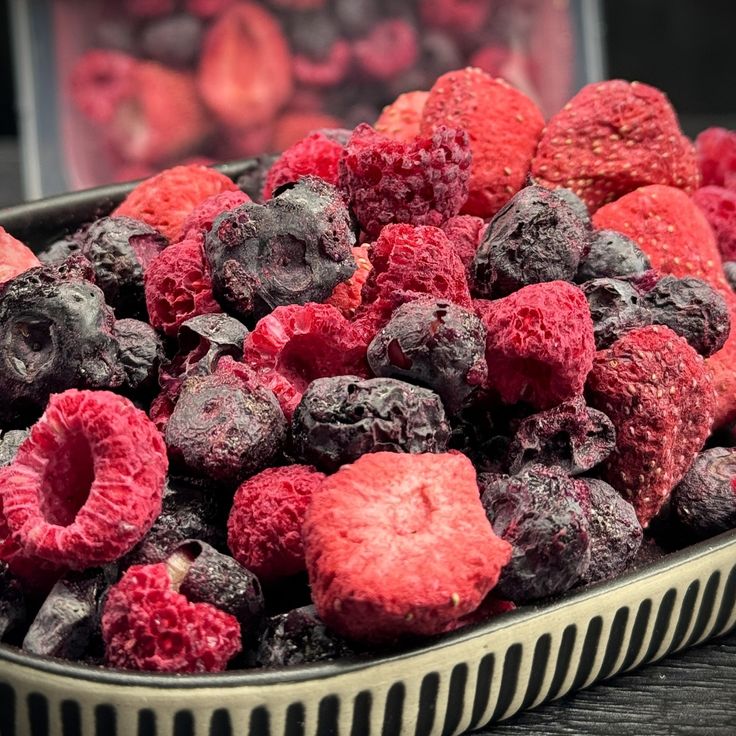 raspberries and blueberries in a bowl on a table