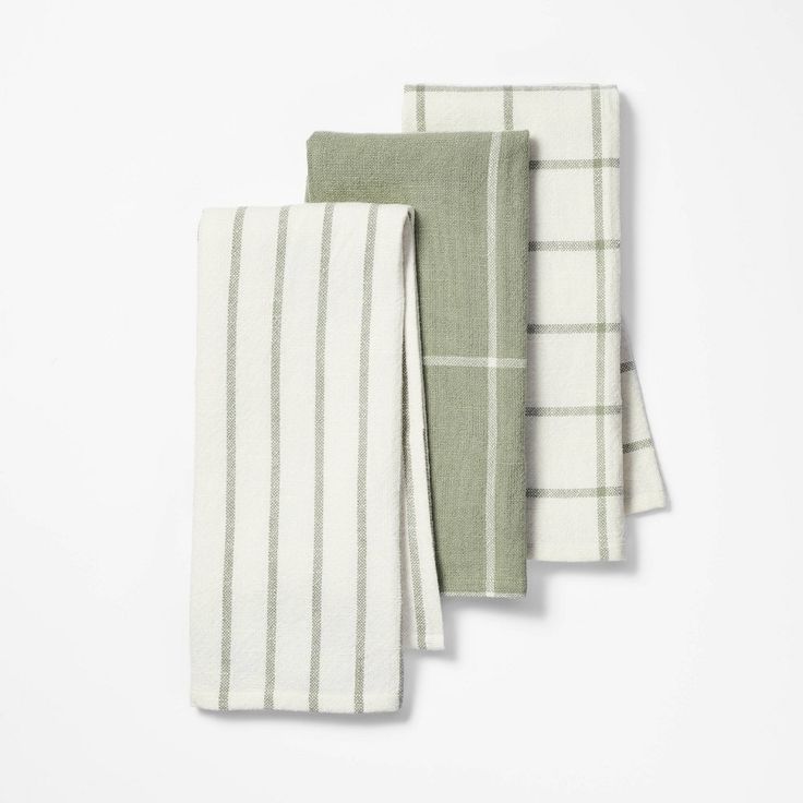 three green and white towels folded on top of each other