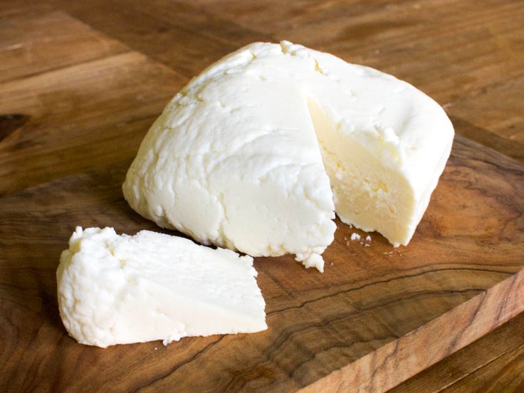 a wooden cutting board with some cheese on it