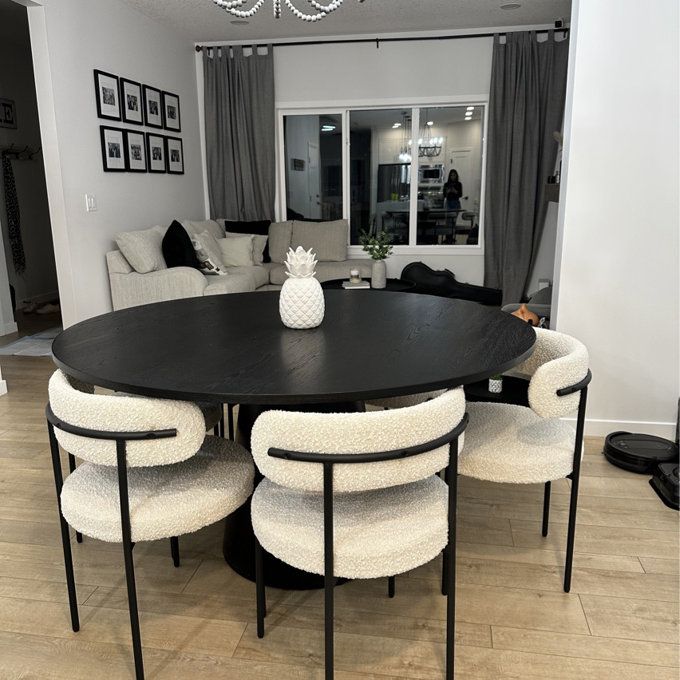 a black table with white chairs around it