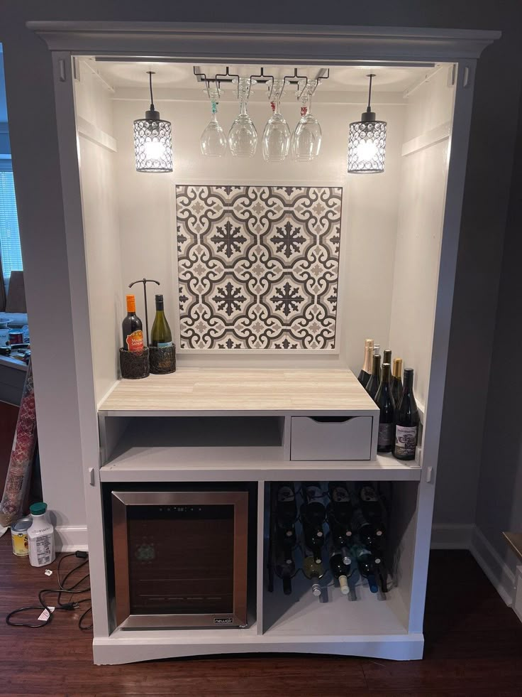 a wine rack with bottles and glasses on it next to a wall mounted art piece