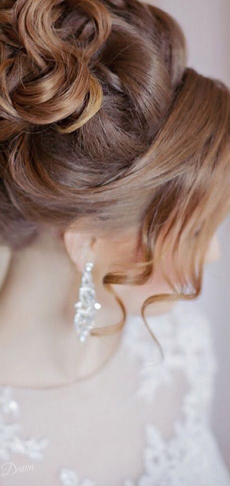 a close up of a woman wearing a wedding dress with braids in her hair