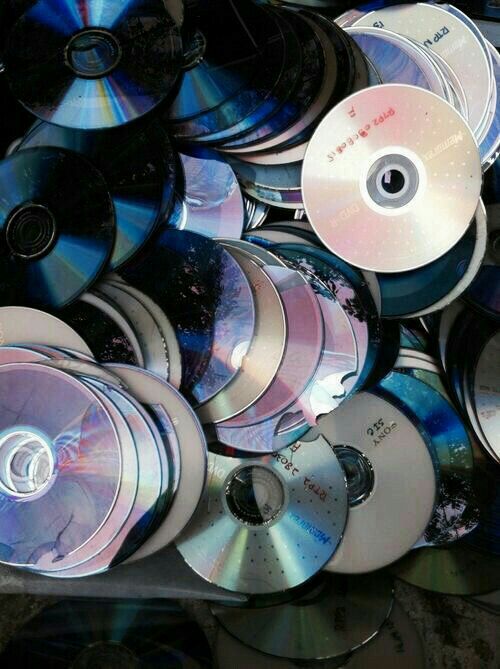 many cds are stacked together in a bin