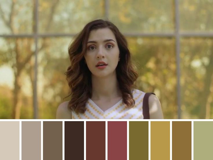 a woman standing in front of a window with lots of color swatches on her face