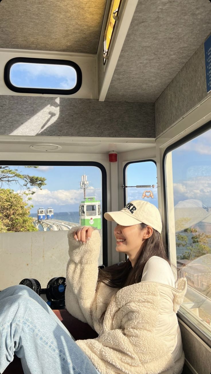 a woman sitting in the back of a bus looking out the window