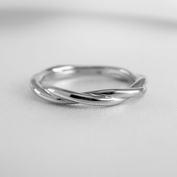 a silver ring sitting on top of a white surface