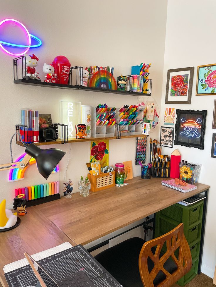 a desk with many items on it and some pictures hanging up above the top shelf