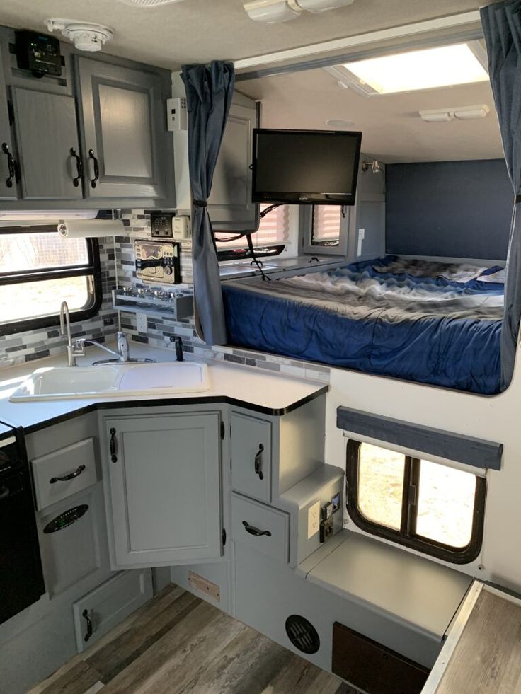 the interior of a camper with its bed and kitchen area is shown in this image