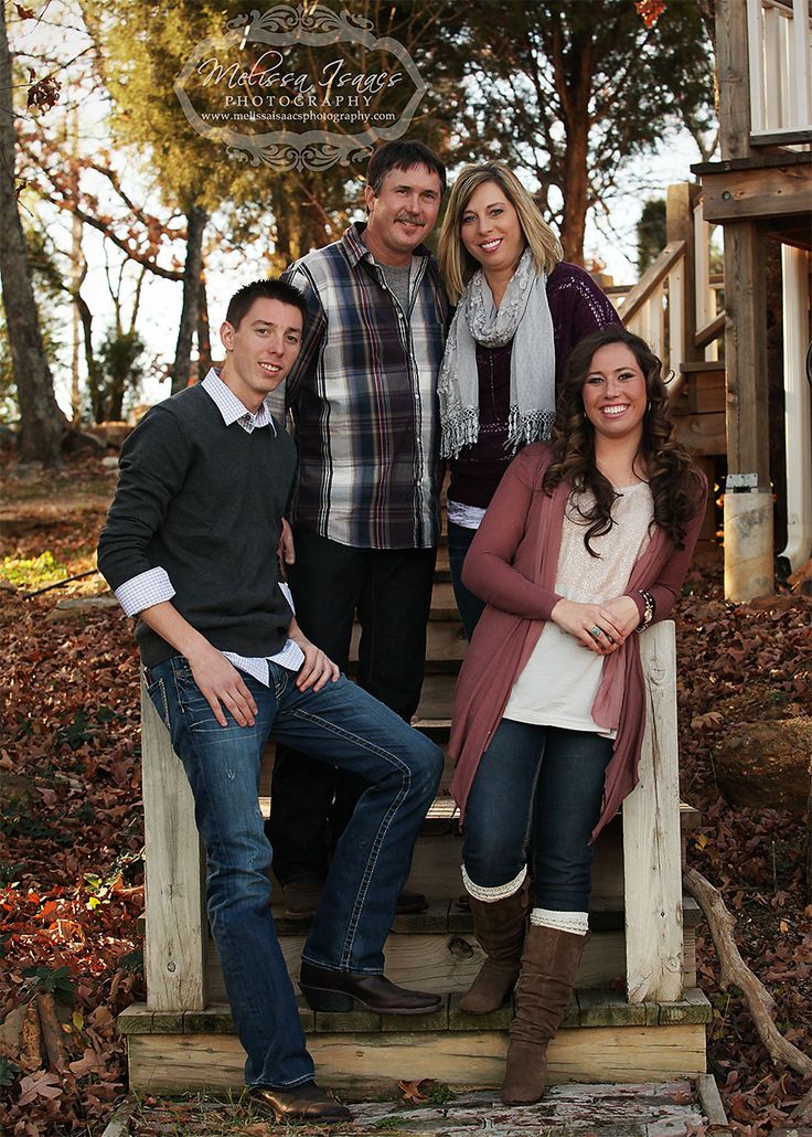 a group of people posing for a photo in front of some stairs and trees with leaves on the ground