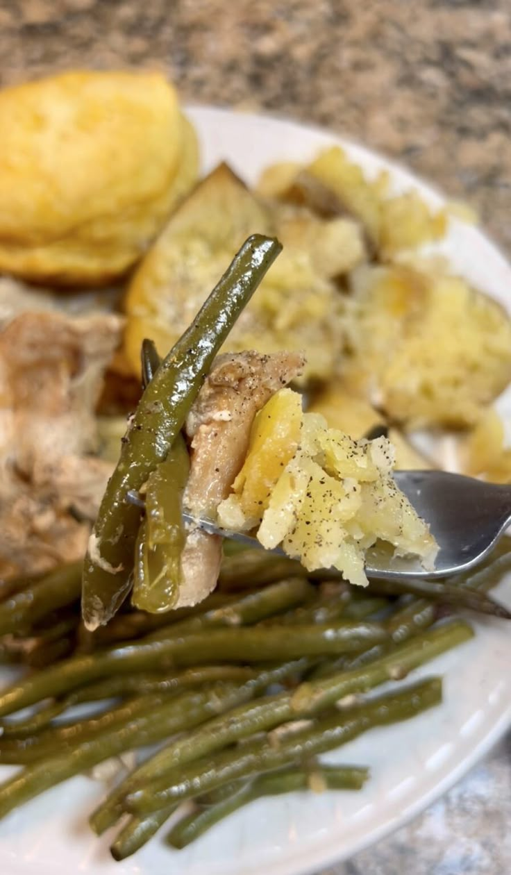 a white plate topped with green beans and potatoes