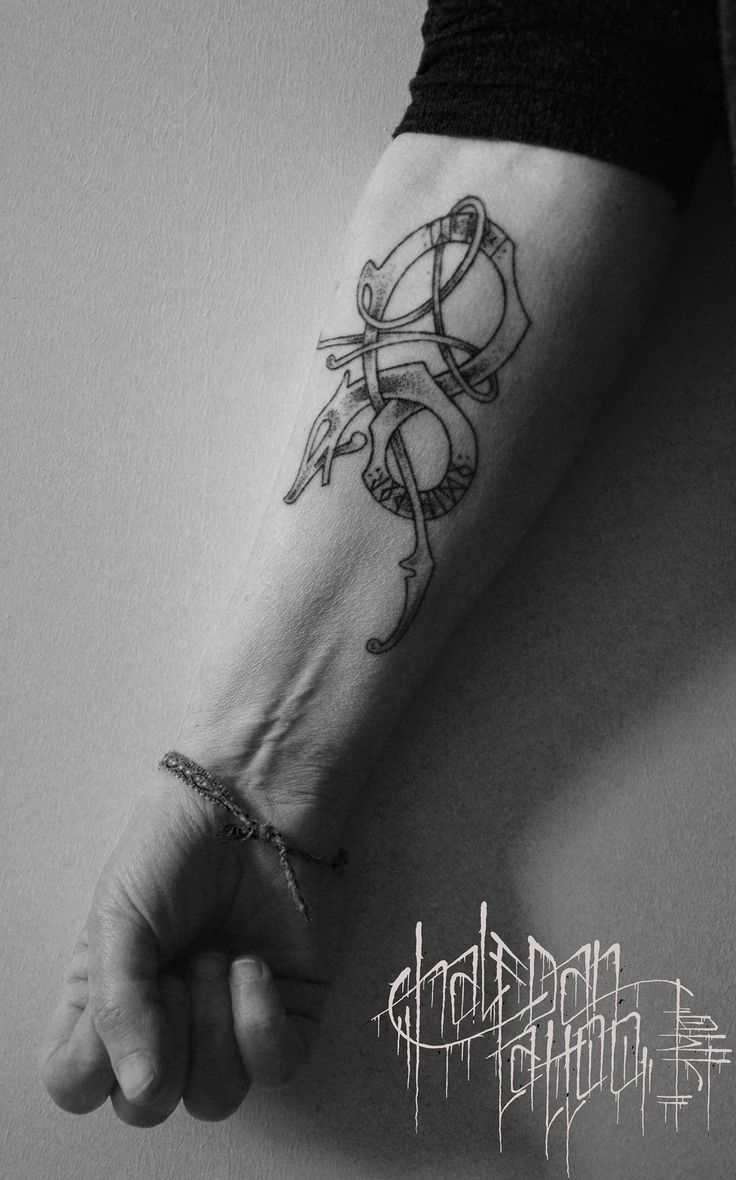 a black and white photo of a person's arm with a tattoo on it