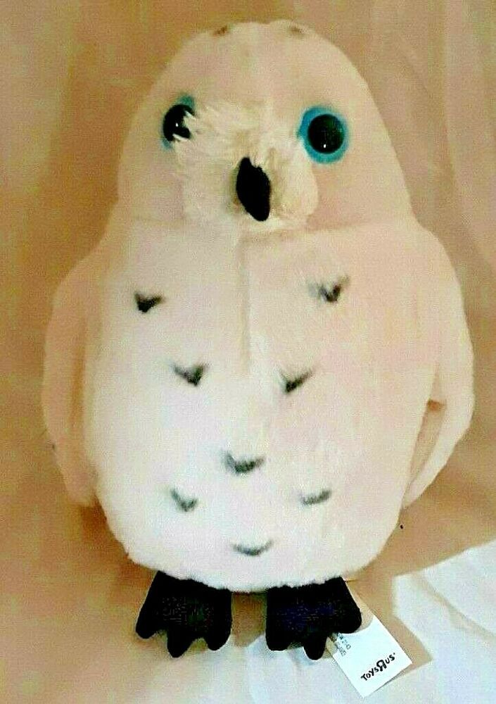 a white stuffed owl with blue eyes and black feet