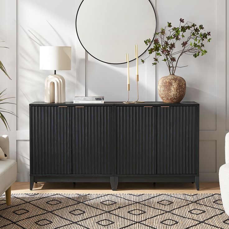 a living room with a white chair and a black cabinet in front of a round mirror