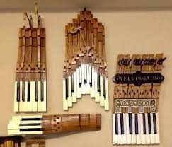 several pieces of art made out of wood and piano keys hanging on the wall next to each other