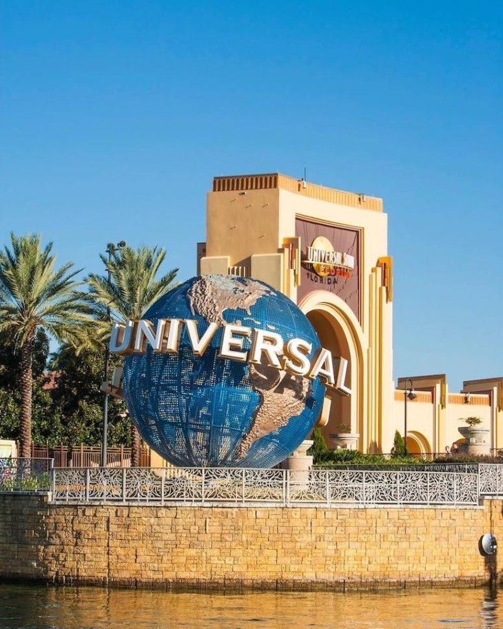 the entrance to universal studios is shown in front of a building with a large globe on it