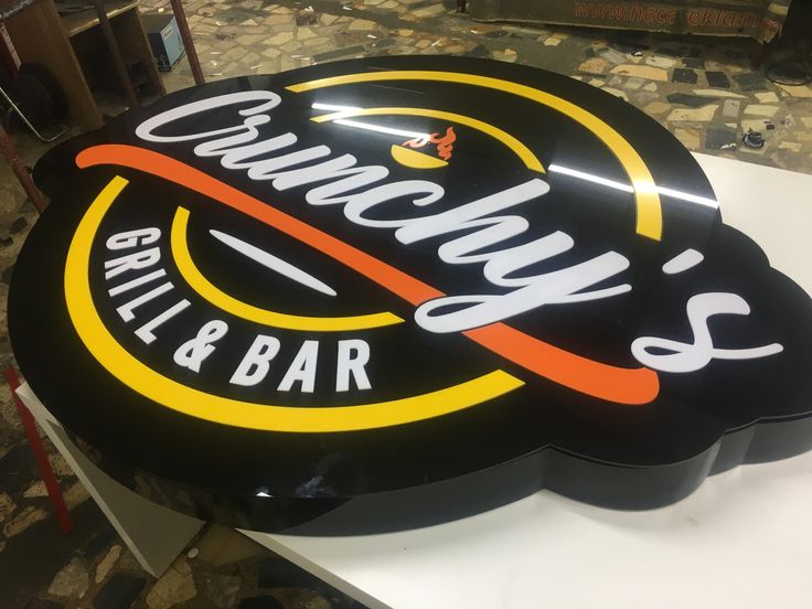 a sign for a restaurant called quincy's grill and bar on a table in front of a fireplace