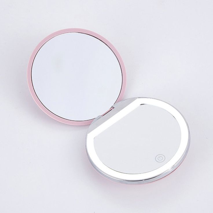 the compact mirror has a pink rim and is reflecting it's image in its reflection