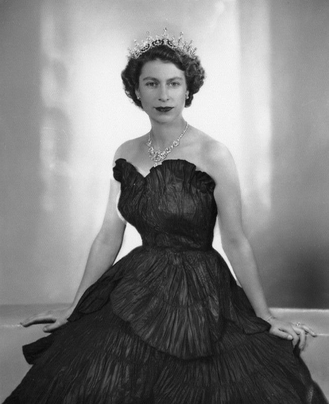 an old black and white photo of a woman in a dress