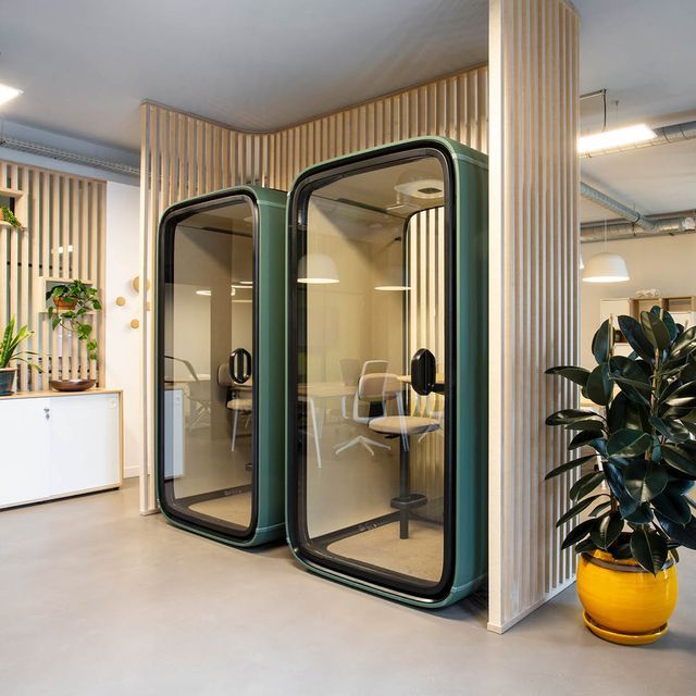 an office cubicle with two doors open and a potted plant in the corner