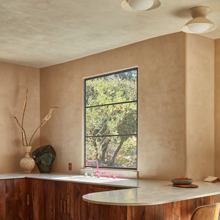 a kitchen with a large window and counter top next to a sink in front of a window