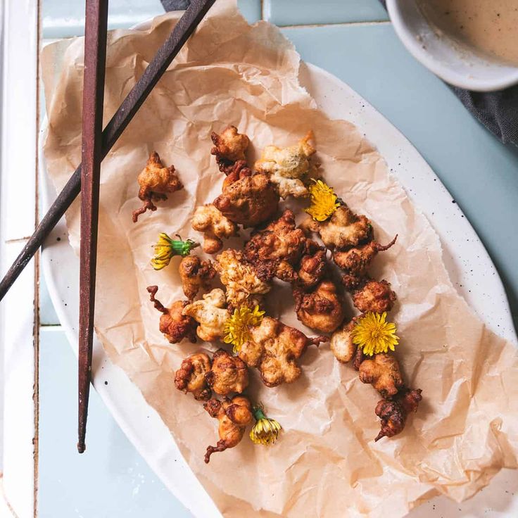 fried food on a plate with chopsticks next to it