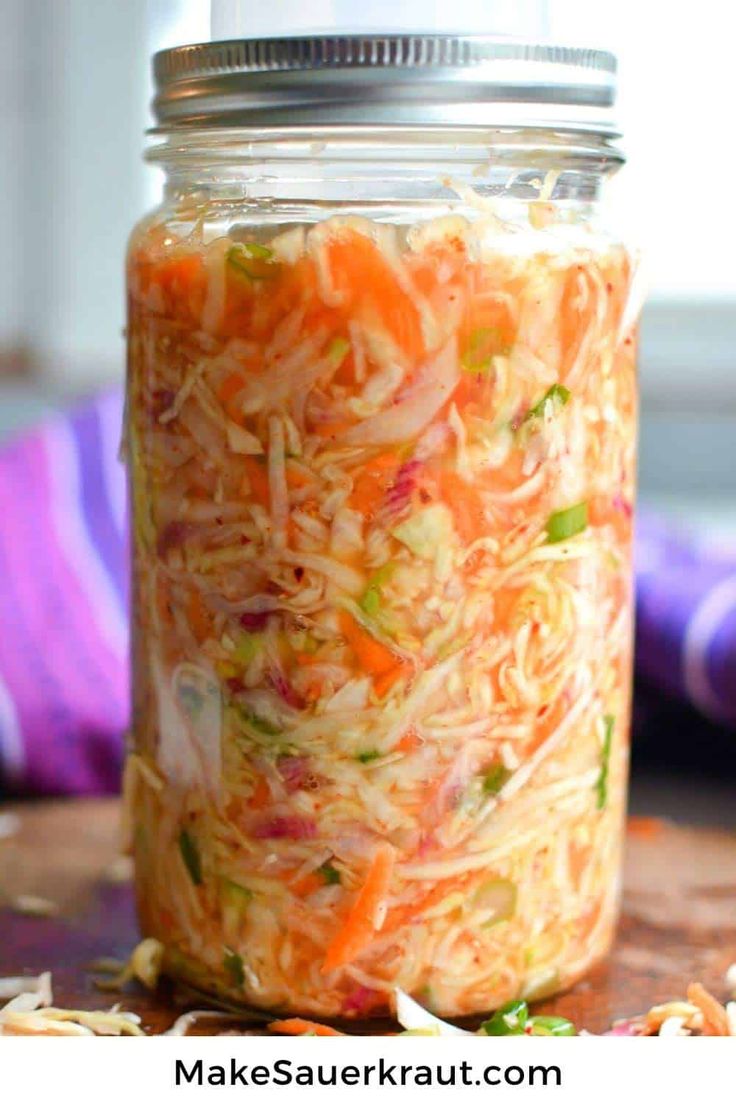 a mason jar filled with shredded carrots and coleslaw