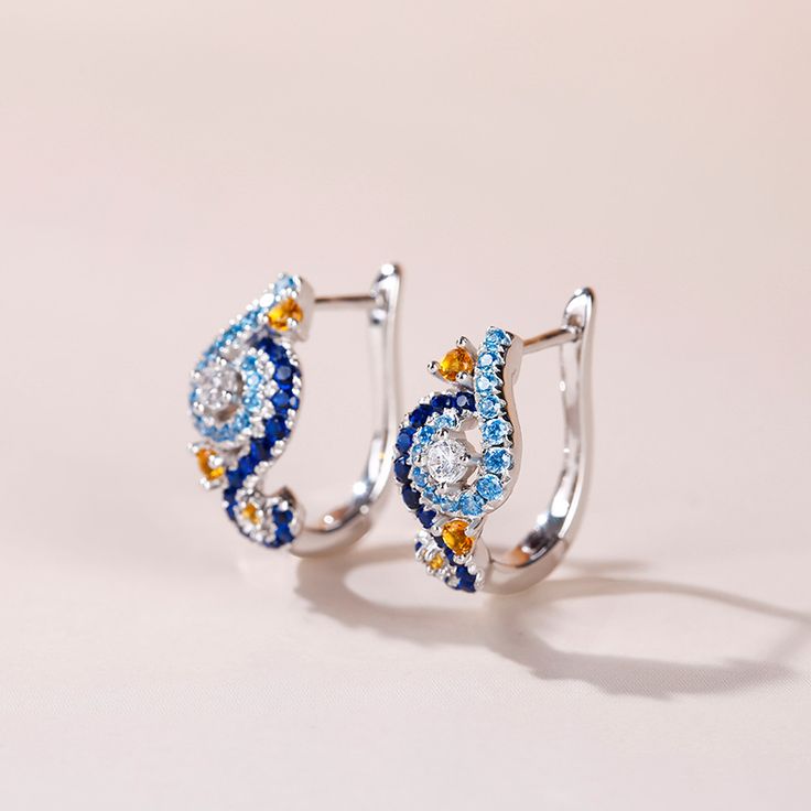 In a stunning display of style and craftsmanship, these earrings are brought to you. A combination of light blue, midnight blue, yellow gold and white stones, the earrings are a premium miniature version of Van Gogh's timeless Starry Night painting. This piece of work reminds us to trust our dreams and not believe the critics of the world. "There is always hope, even in the darkest of times." So trust your dream and let this alluring jewelry make a statement.Carat Weight: 2.584 ctStone Size: 2.5 Blue Diamond Hoop Earrings Fine Jewelry, Blue Diamond Hoop Earrings, Blue Diamond Round Hoop Earrings, Blue Diamond Drop Earrings With Accents, Blue Teardrop Diamond Earrings For Anniversary, Blue Cubic Zirconia Hoop Earrings For Anniversary, Blue Teardrop Diamond Earrings, Blue Diamond Gemstone Earrings In Fine Jewelry Style, Luxury Blue Diamond Earrings With Accents