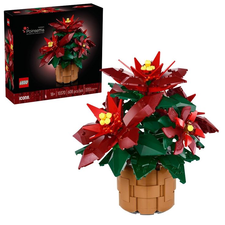 a small potted plant with red and yellow flowers in it next to a box