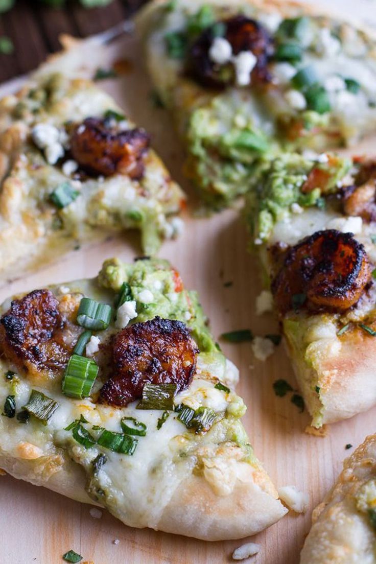 a pizza with broccoli, cheese and other toppings on a cutting board