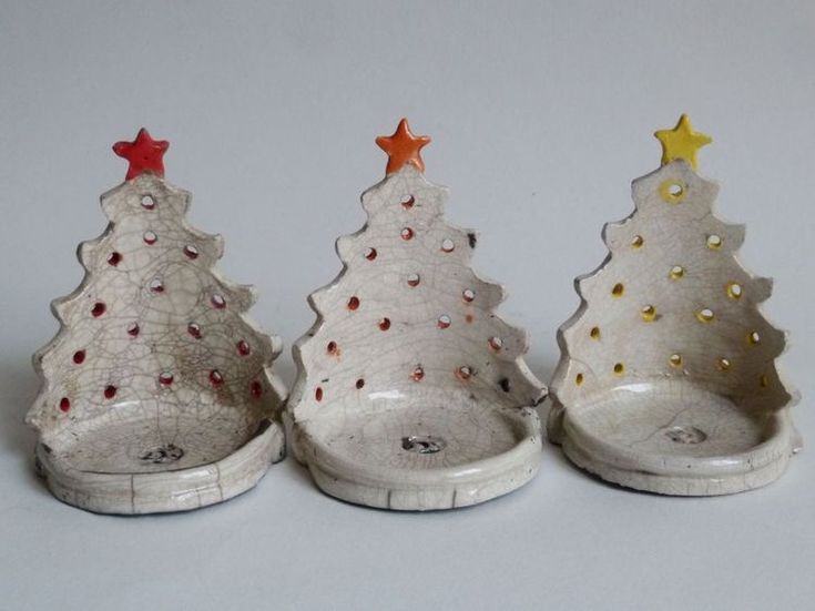 three ceramic christmas trees sitting next to each other