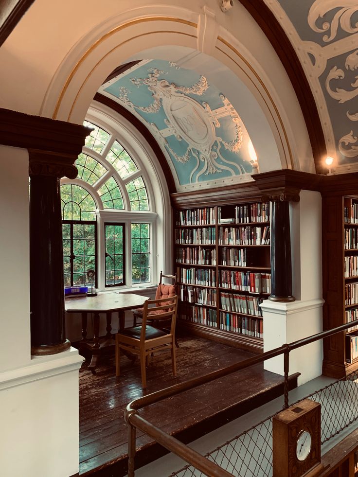 an arched room with bookshelves filled with lots of bookcases and chairs