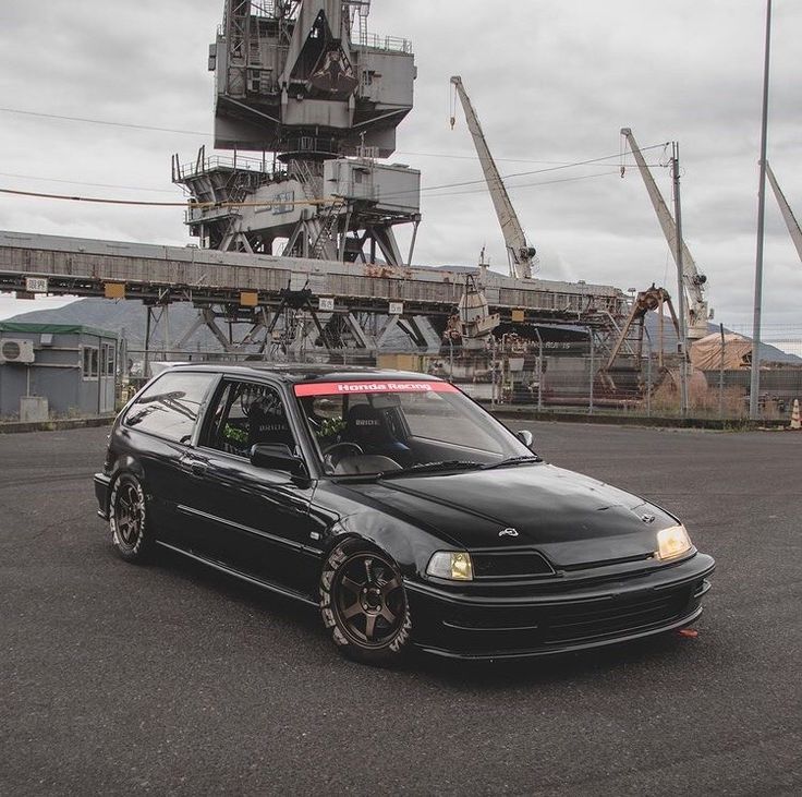 a black car parked in front of an airplane