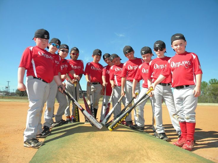 a group of young men standing next to each other on top of a baseball field