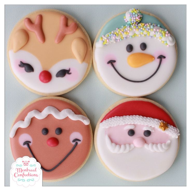 four decorated cookies with frosting on top of each one, including santa claus and snowman