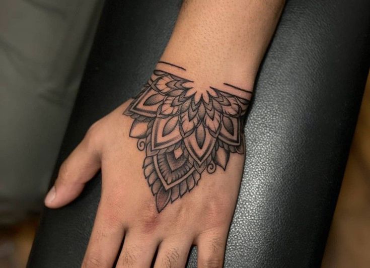 a person's hand with a tattoo design on the left side of their palm