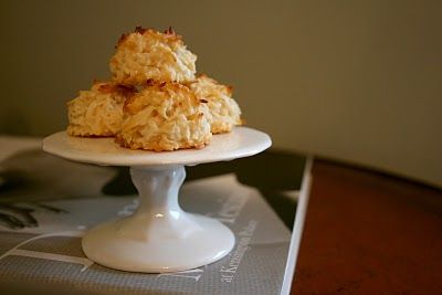 some food is sitting on top of a white cake plate with silverware in front of it