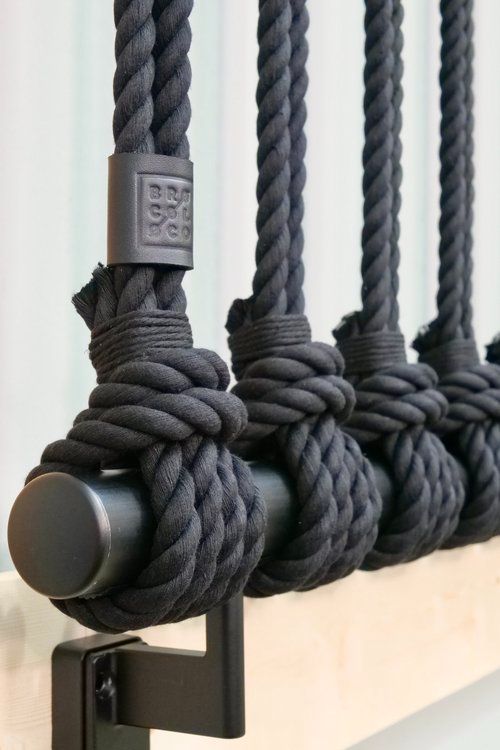 three black ropes hanging on the side of a wall