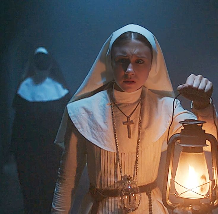 the nun is holding a lantern in her hand