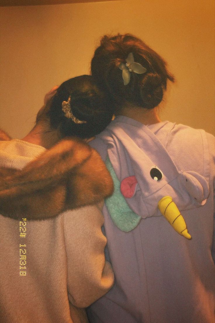 two girls hugging each other while wearing pajamas