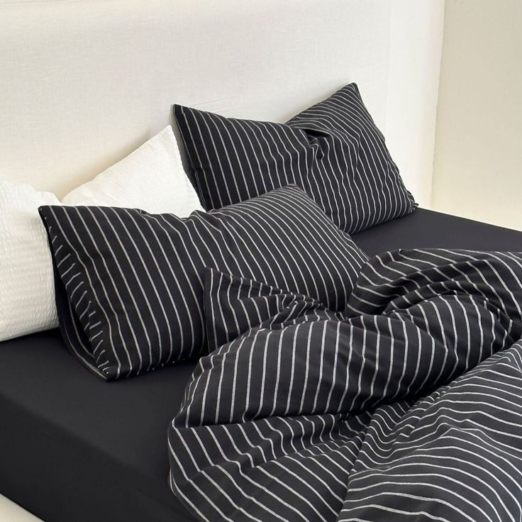 black and white striped bedding with pillows on the headboard in front of it