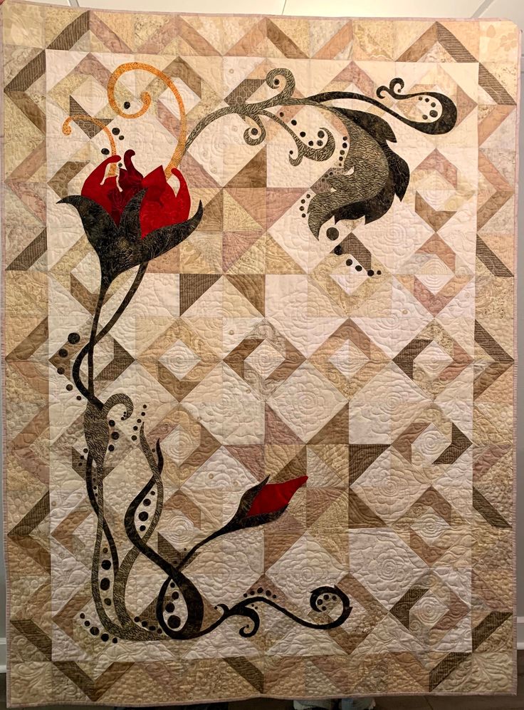 a quilted wall hanging with an abstract design on the front and side of it