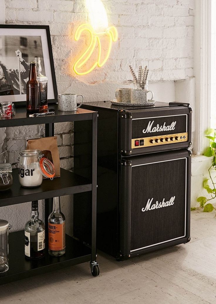 an old fashioned amp stands in front of a brick wall with a neon sign above it