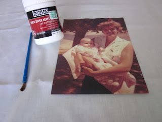 an image of a woman holding a baby on her lap next to a paint bottle