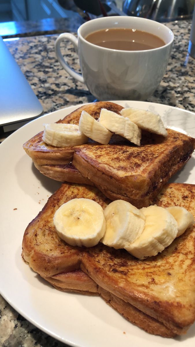 french toast with banana slices and syrup on a plate next to a cup of coffee