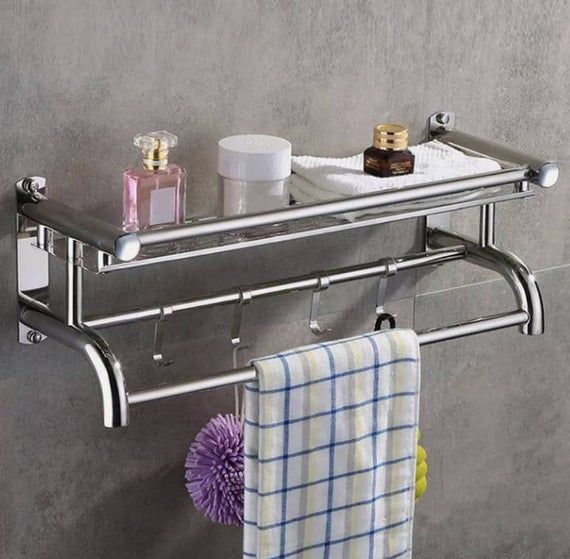 a towel rack with two towels hanging from it's sides and soap bottles on the other side